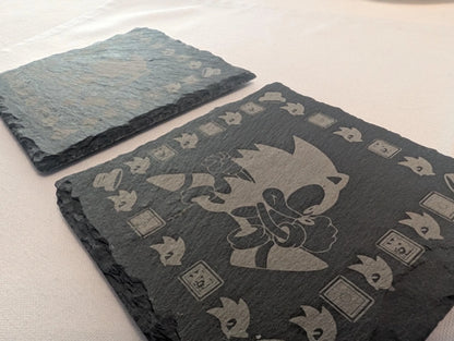 Engraved slate coasters featuring a cartoon character and decorative border on a table