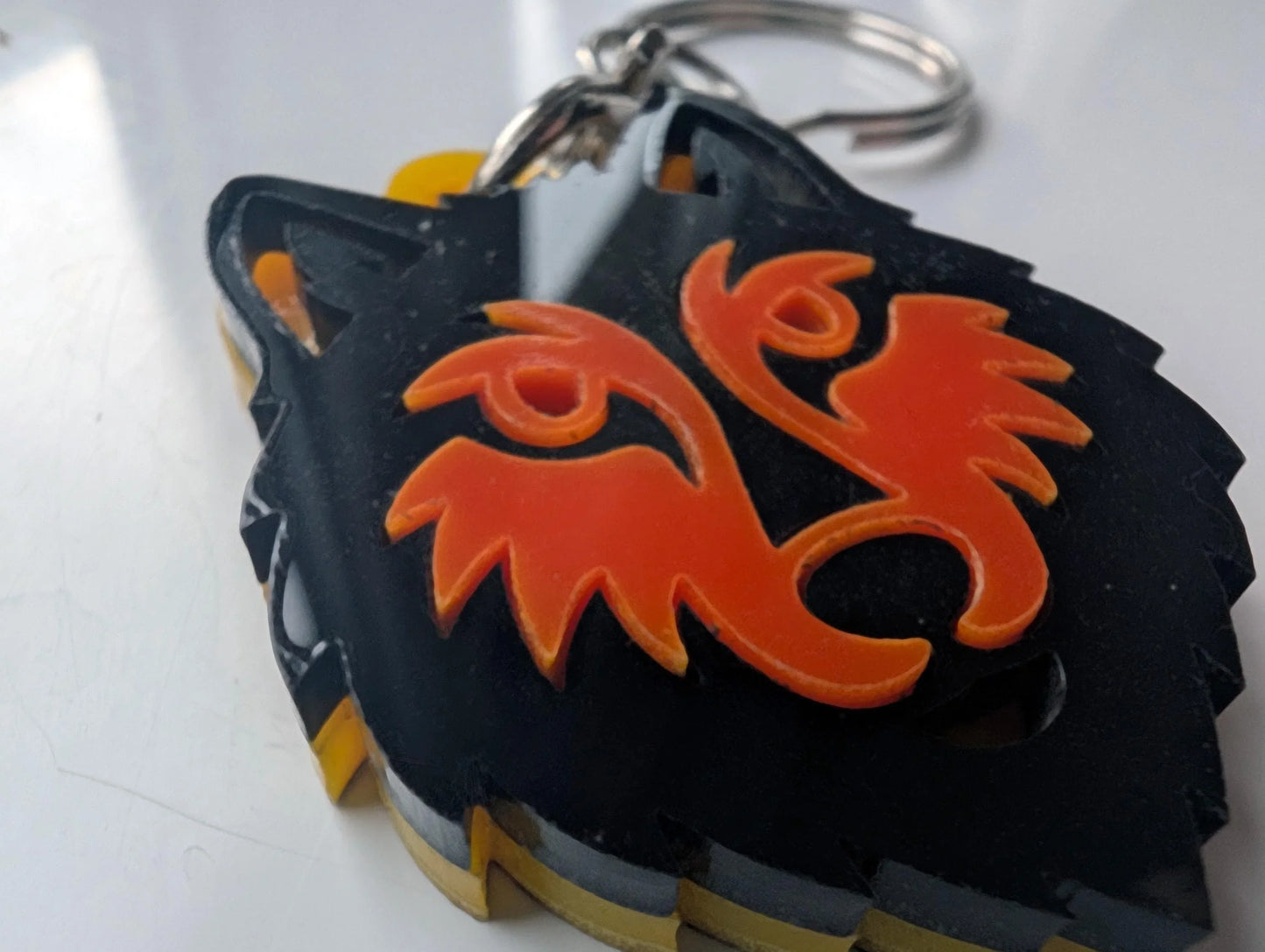 Custom acrylic keychain in the shape of a wolf head with red decorative accents