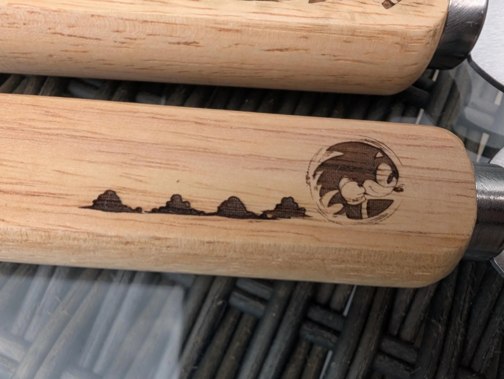 Wooden handle with engraved cartoon character and mountain silhouette, custom made detail