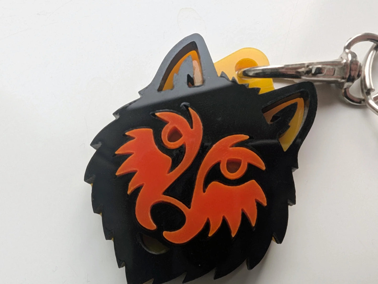 Custom acrylic keychain shaped like a wolf head with orange and black details