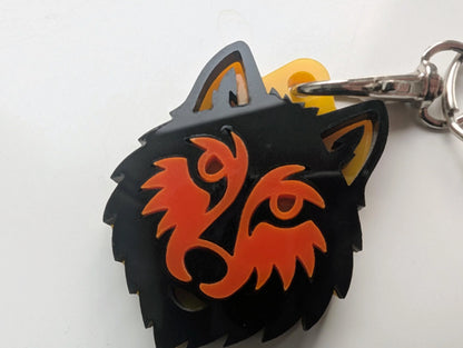 Custom acrylic keychain shaped like a wolf head with orange and black details