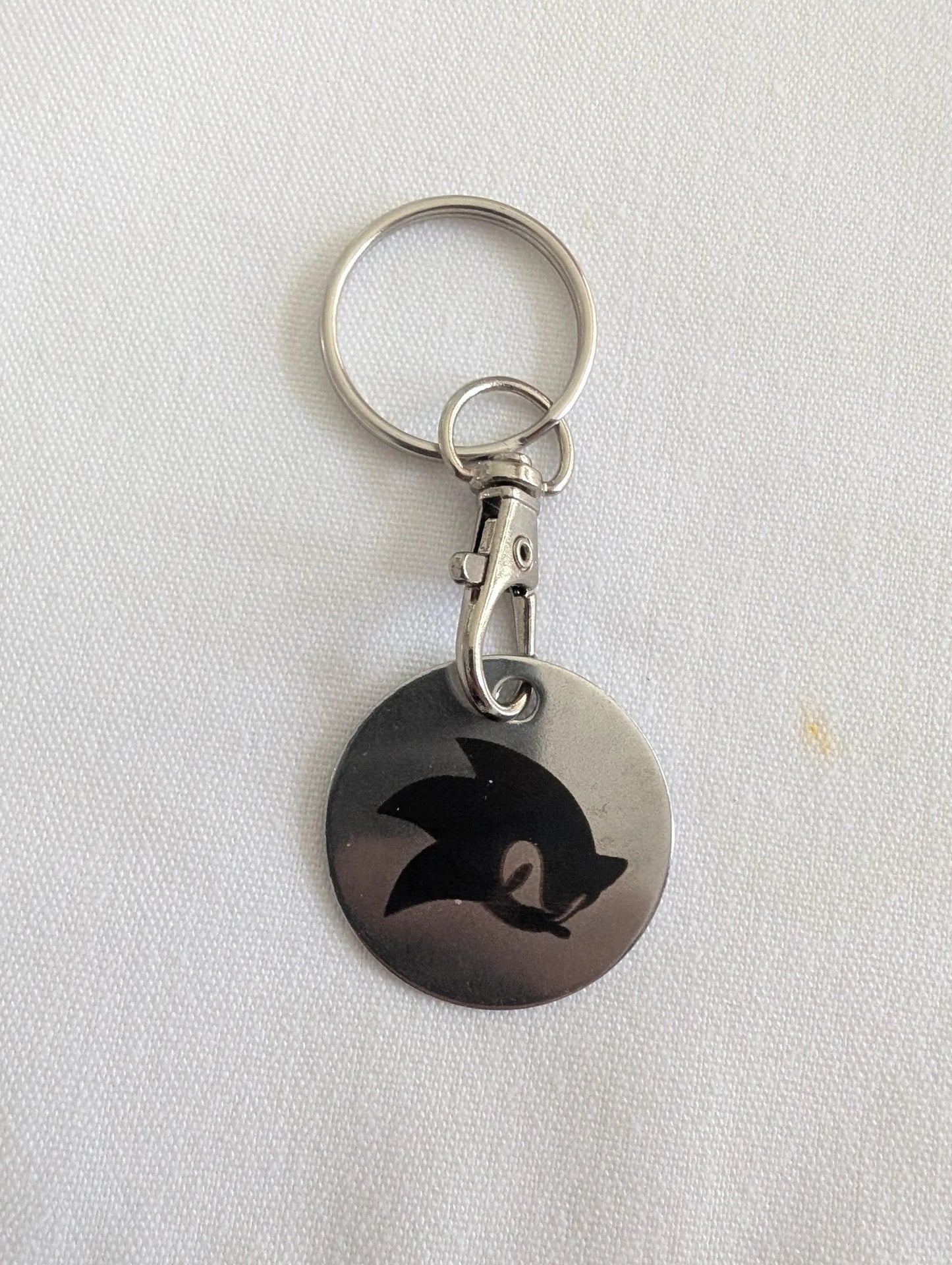 Custom metal keychain with engraved black abstract animal design on white background
