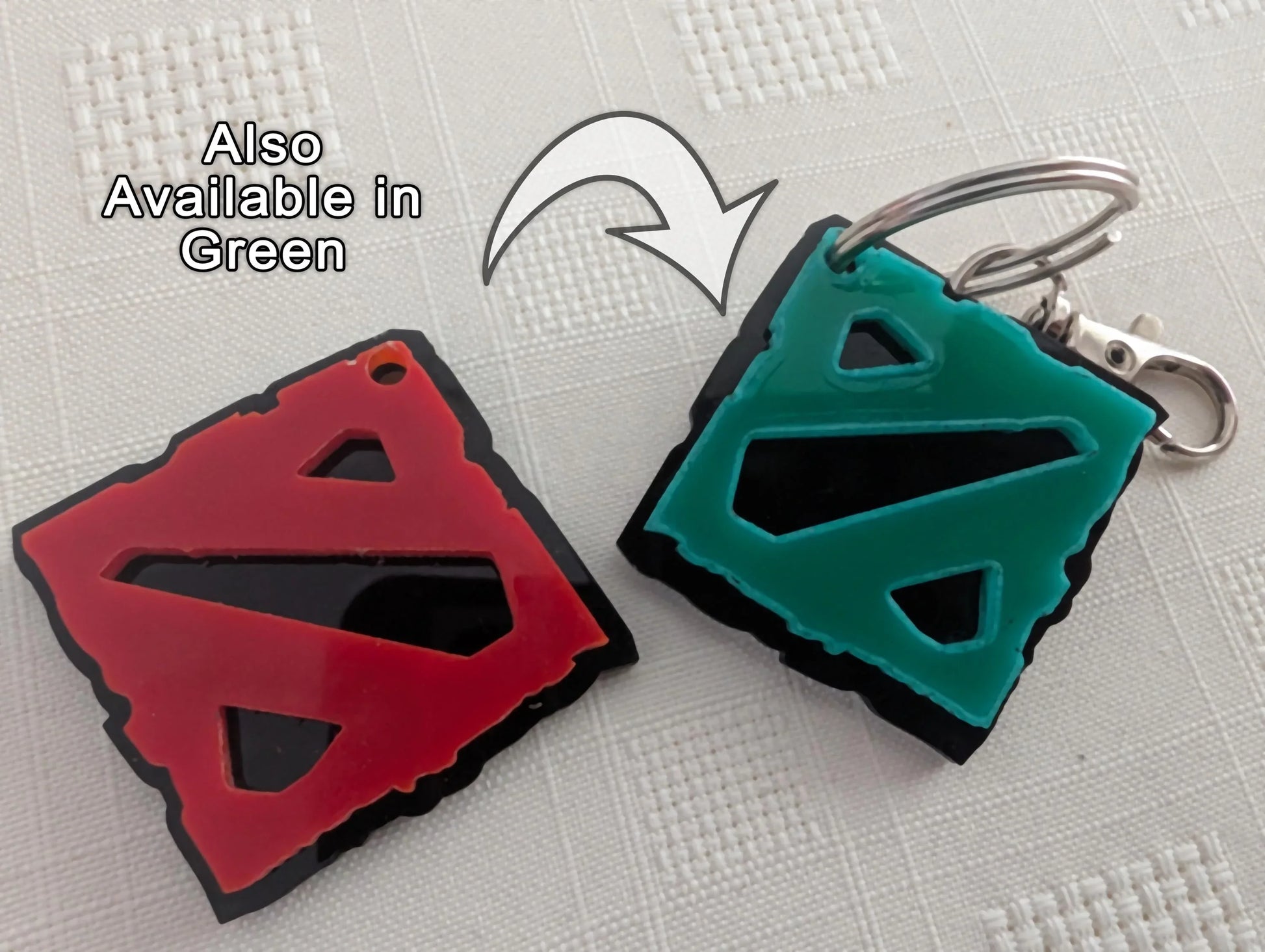 Custom acrylic keychains in red and green with geometric cutout designs on white background