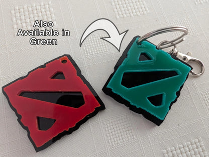 Custom acrylic keychains in red and green with geometric cutout designs on white background