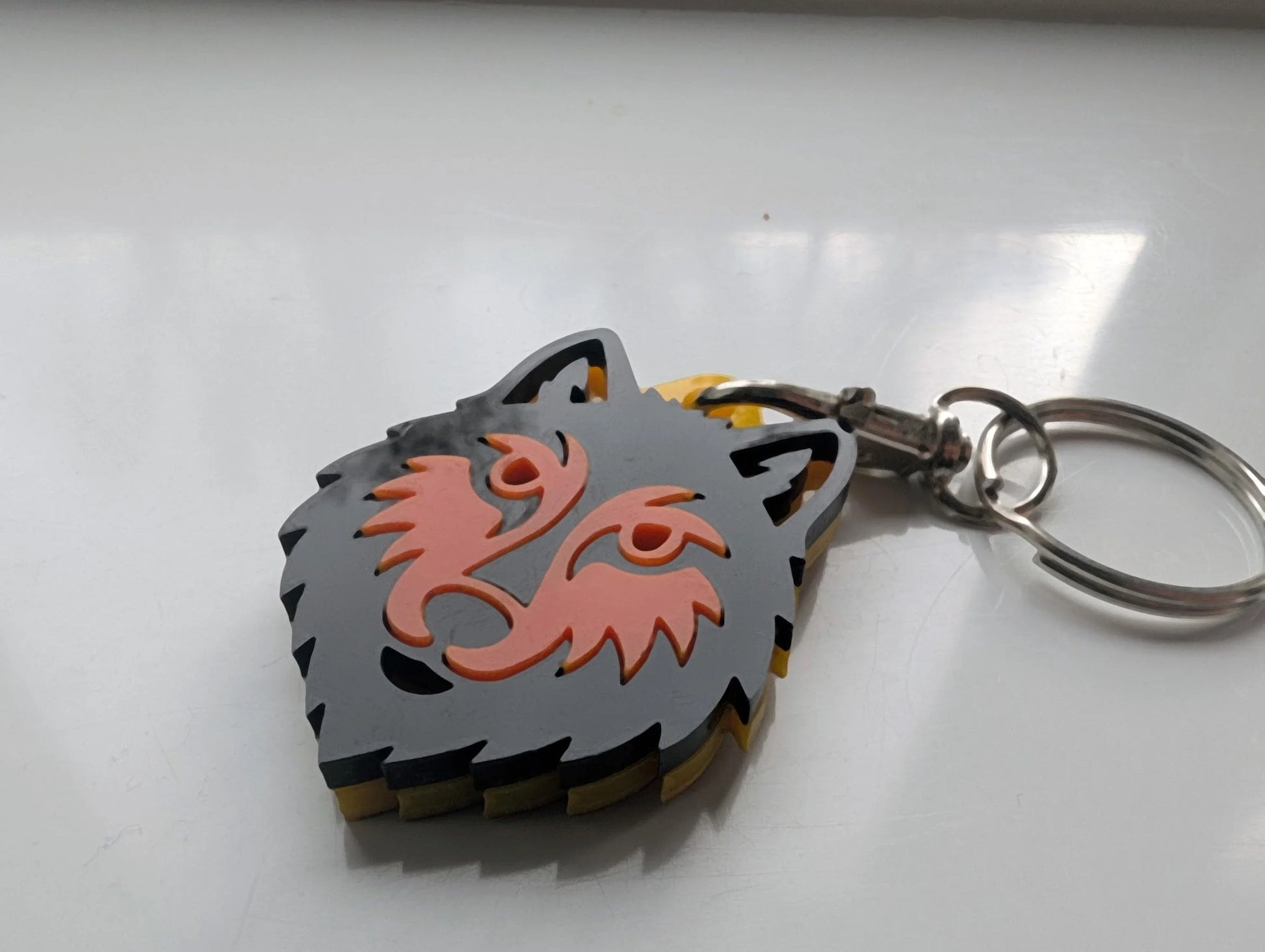 Custom acrylic wolf head keychain with layered grey and orange design on metal ring