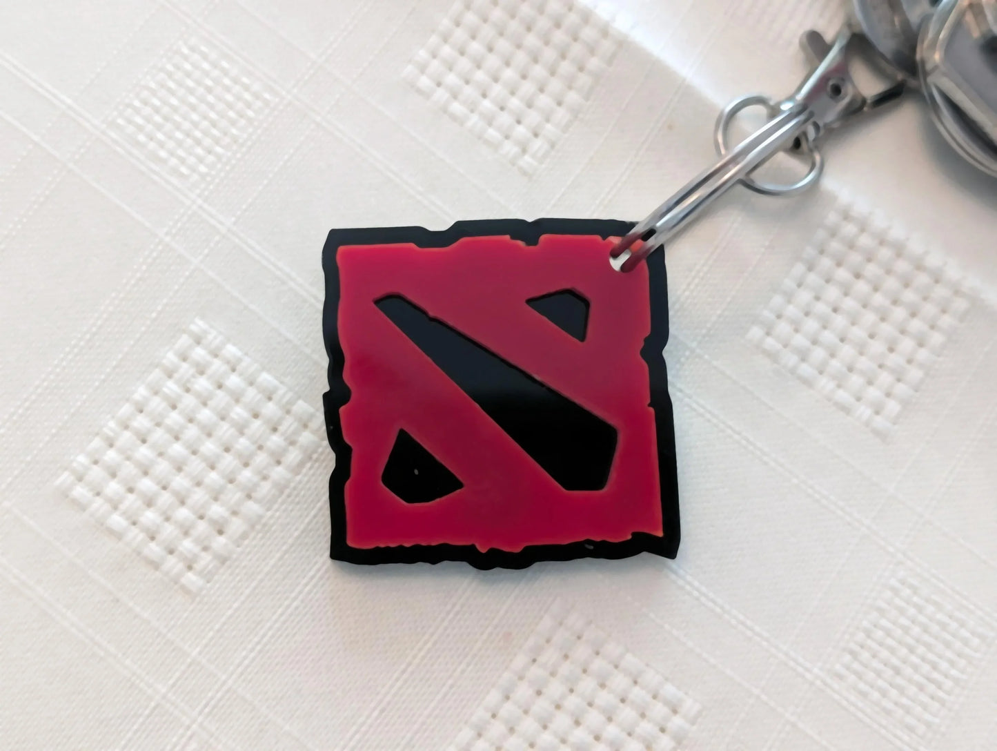 Red and black acrylic custom keychain on white textured background
