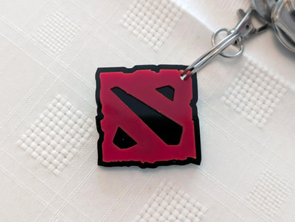 Red and black acrylic custom keychain on white textured background