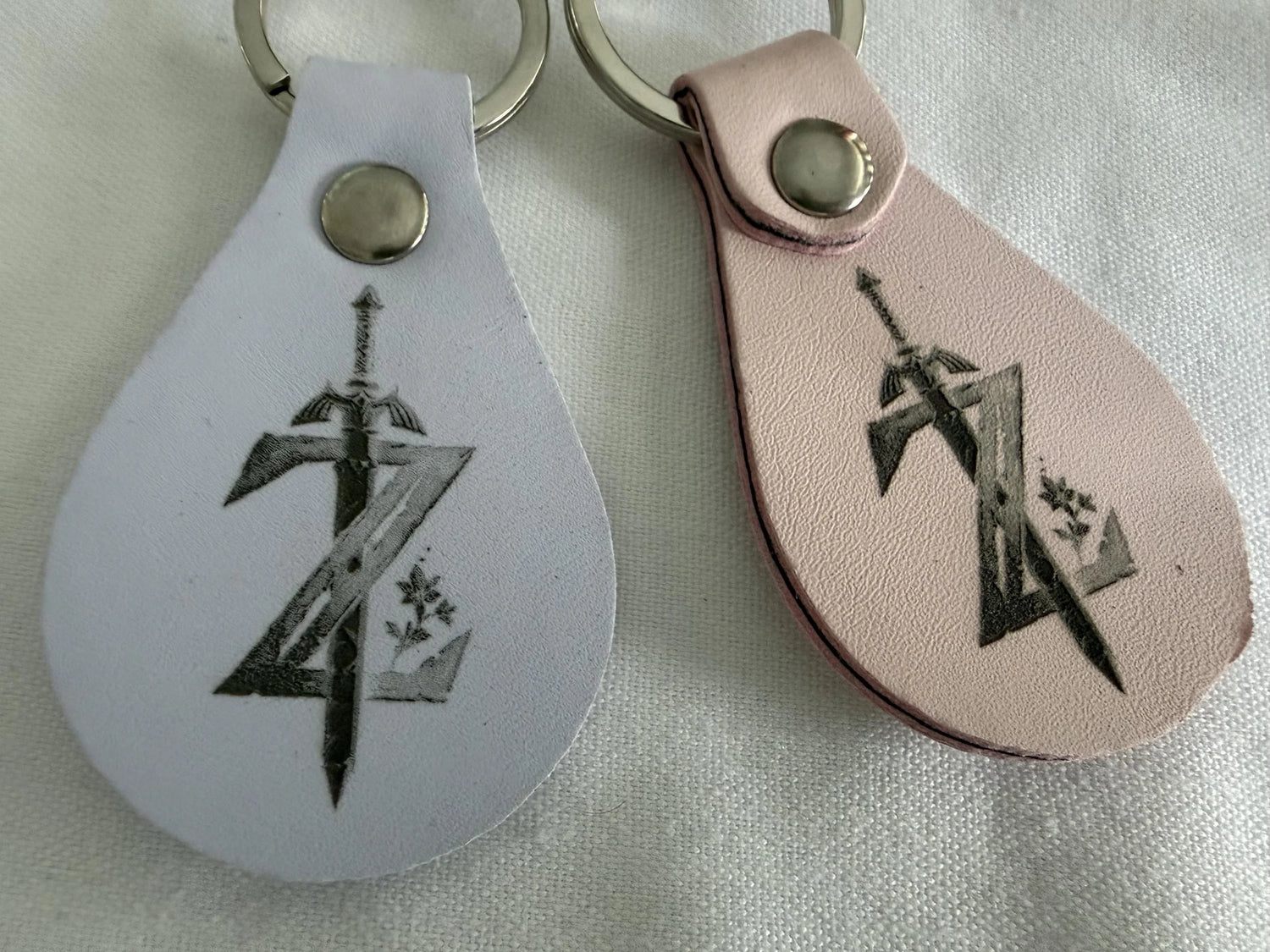 Custom leather keychains with engraved sword and Z design on white background
