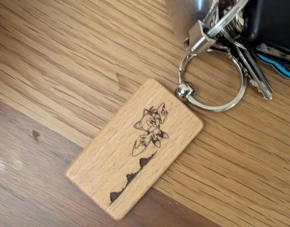 Custom engraved wood keychain with floral design on metal keyring, on wood table