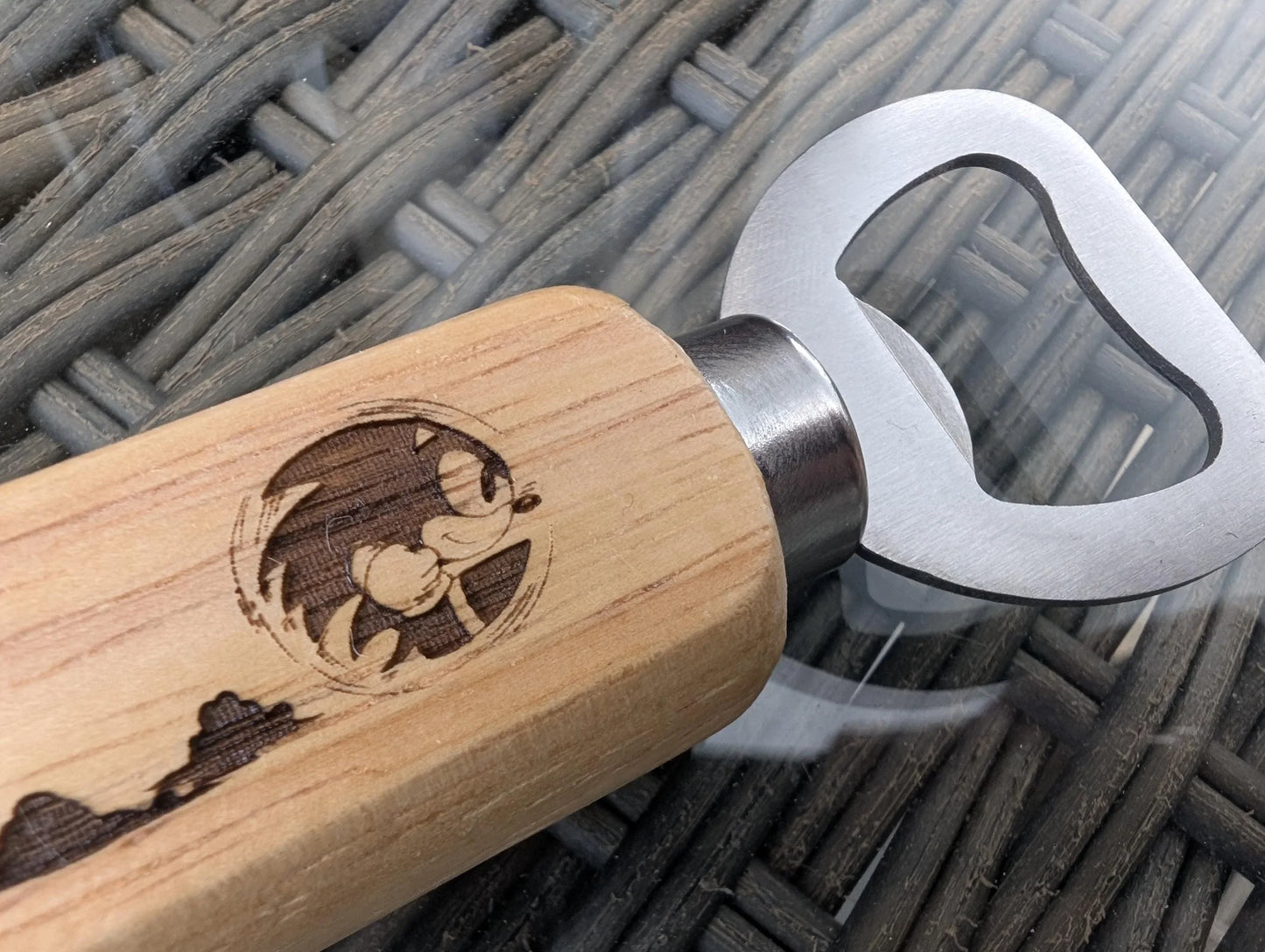 Wood handled metal bottle opener with engraved cartoon design on handle