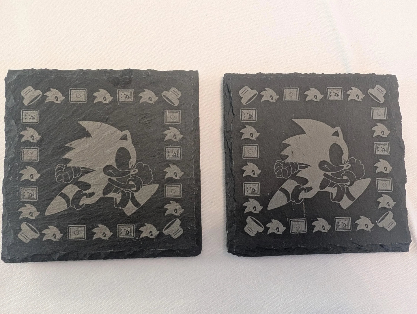 Custom engraved slate coasters with running character design and retro gaming motifs