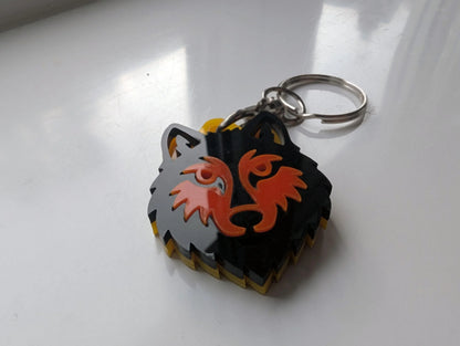 Custom acrylic wolf head keychain with layered black, orange, and yellow design on metal ring