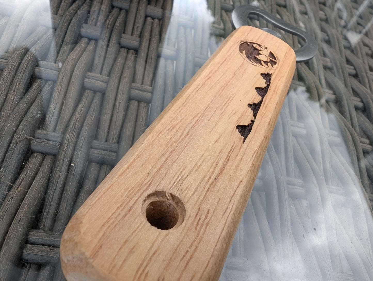 Wooden bottle opener with engraved map design on glass table