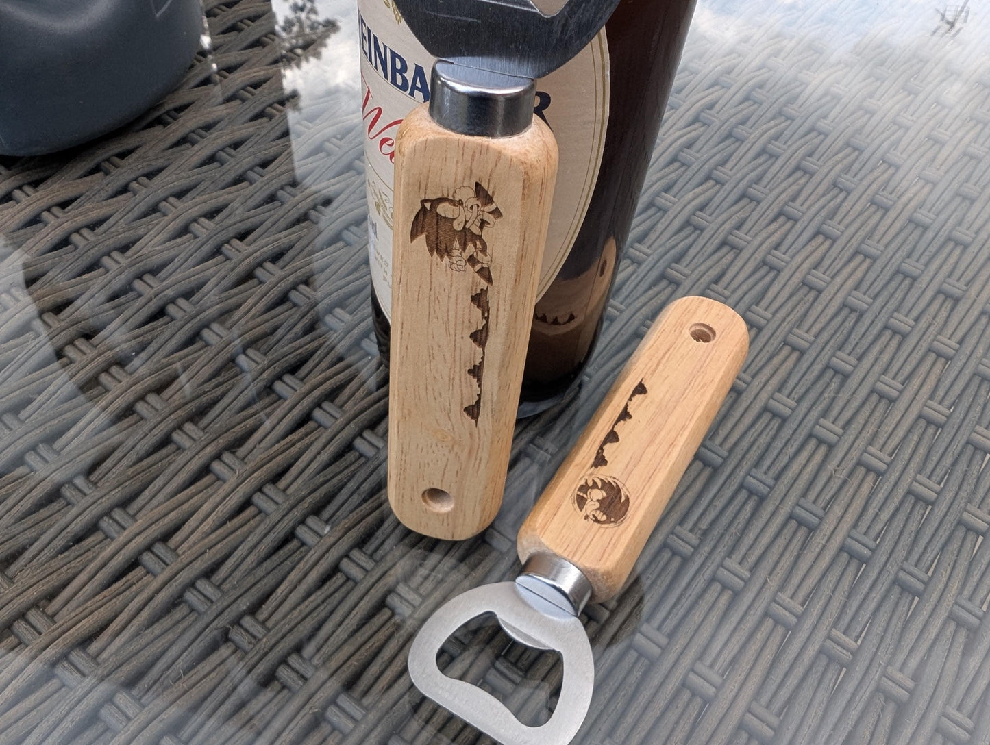 Custom engraved wooden handle bottle openers with mountain design on glass table