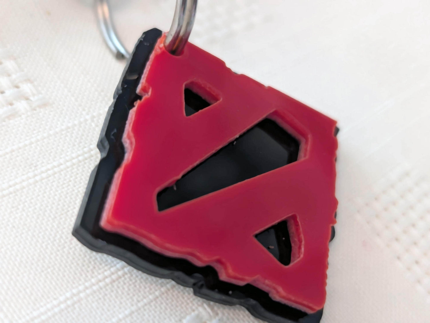 Custom acrylic keychain with red geometric cutout design on black base