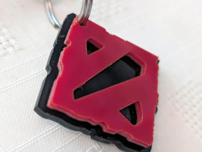 Custom acrylic keychain with red geometric cutout design on black base