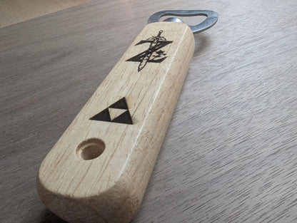 Wooden handle bottle opener with engraved sword and triangle symbols on a wood surface