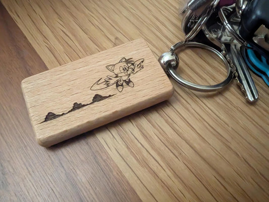 Custom engraved wooden keychain with cartoon design on metal keyring, on wood surface